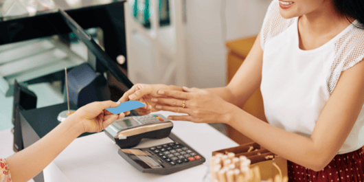 woman handing credit card to cashier for payment